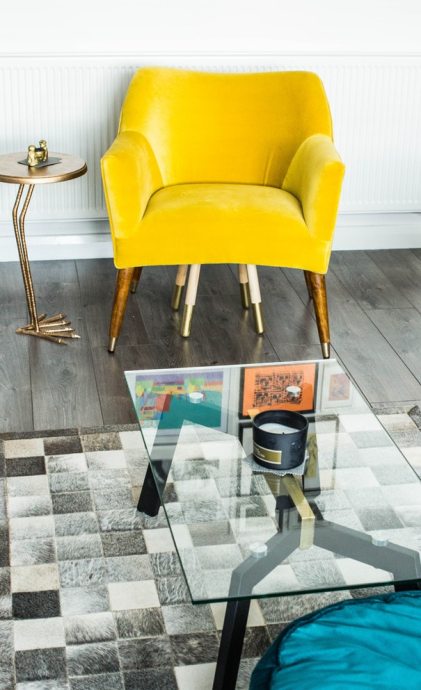 living room space with yellow arm chair and glass table